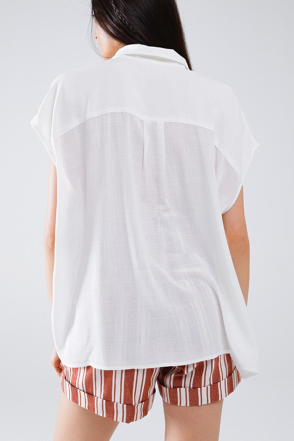 Blusa blanca abotonada con cuello polo