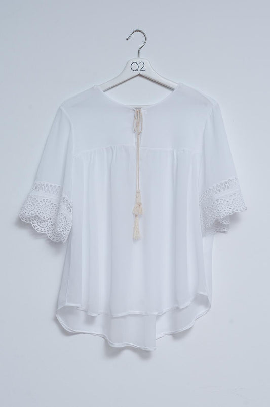 Q2 Blusa blanca con lazadas en la parte delantera y bordados