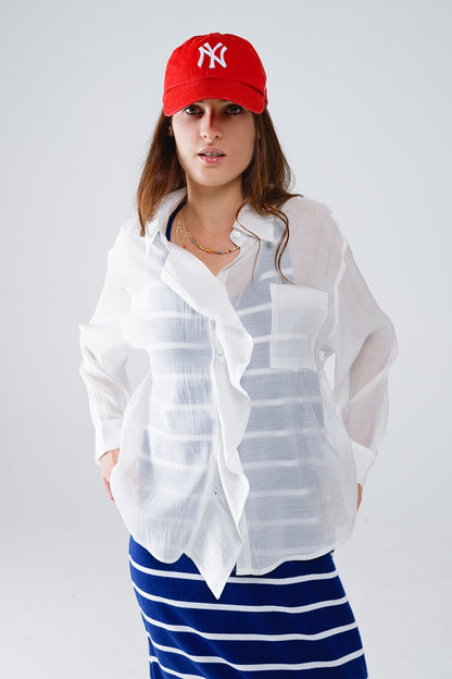 Blusa blanca semitransparente con detalle de volante en la parte delantera