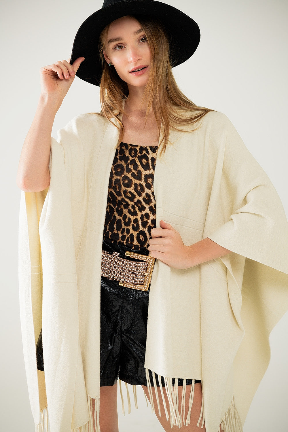 Suave poncho de punto beige con flecos