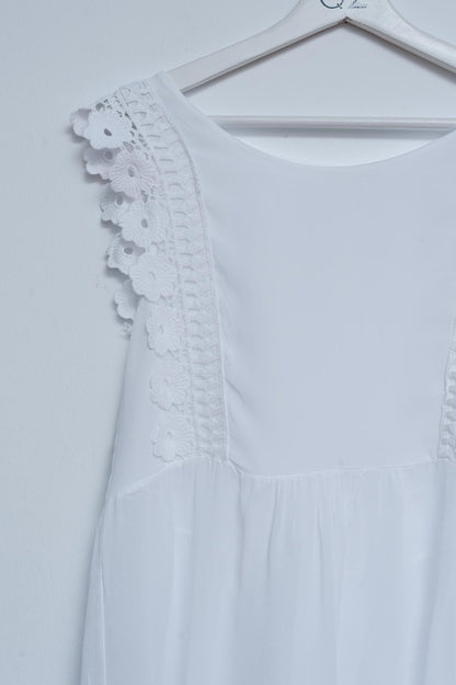 Top blanco con diseño bordado y detalle de volantes