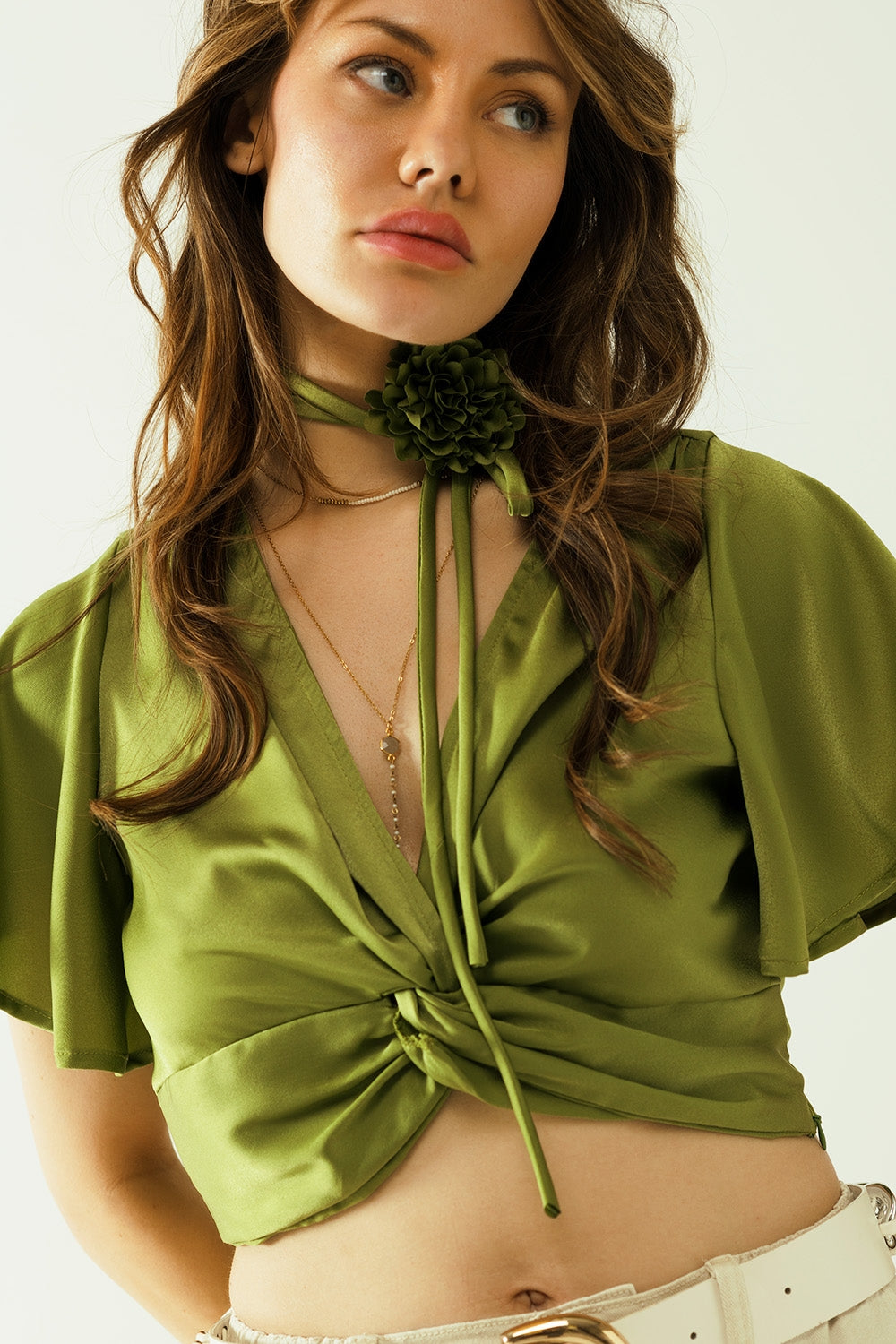 Top verde con cuello en V manga corta y detalle floral en el cuello